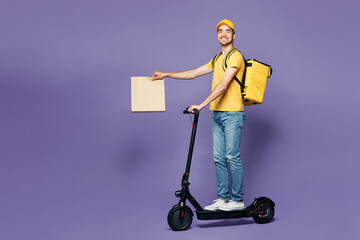 Full body young delivery guy employee man wear yellow cap t-shirt uniform workwear thermal bag work...