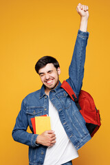 Young boy student wears jeans casual clothes backpack bag hold books doing winner gesture celebrate...