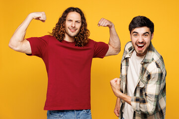 Young two friends buddies men they wear casual clothes together showing biceps muscles on hand...