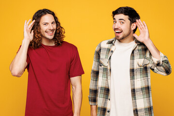 Young happy two friends buddies men they wear casual clothes together try to hear you overhear...