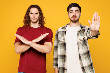 Young two friends buddies men they wear casual clothes together holding folded crossed hands in...