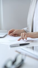 Businesswoman reviewing financial documents and charts, performing data analysis for business planning and decision making in a professional office background. Business people concept