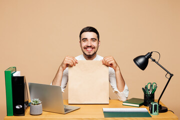 Young happy employee business man wears white shirt tie sit work at office desk with pc laptop hold...