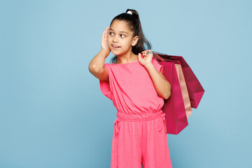 Little nosy kid girl 9-10 years old wear pink clothes hold paper package bags after shopping try...