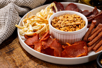 Close-up of rustic meat and cheese beer snacks with peanuts