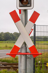 Red and white railroad crossing sign showing upcoming train