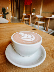 Cozy café interior featuring a decorative cup of latte on a wooden table
