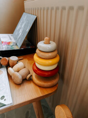 Colorful wooden stacking rings on a table in a cozy play area for children