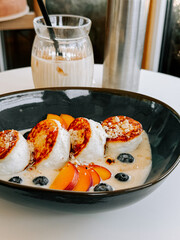 Delicious breakfast bowl featuring fluffy pancakes, fresh fruits, and creamy yogurt in a cozy cafe
