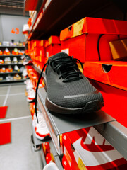 Shoe displayed on shelf in retail store with vibrant packaging in background