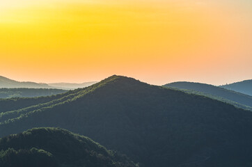 Picturesque sunset over forested hills near Solina Lake, Bieszczady Mountains, Poland &ndash; serene landscape with warm golden light, natural scenery, and peaceful countryside atmosphere