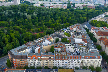 Aerial view of a unique triangular building nestled amongst verdant trees and urban structures, Friedrichshain-Kreuzberg, Berlin, Volkspark Friedrichshain, Germany.