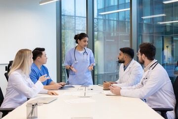 A diverse medical team in a modern office setting, engaged in a collaborative discussion around a...