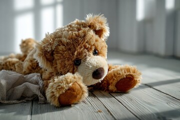 Obraz premium Broken teddy bear rests sideways on a clean light wooden floor, reflecting quiet moments of nostalgia and emotional minimalism