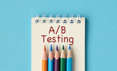 A set of pencils are on a notebook with the words A/B Testing written on it