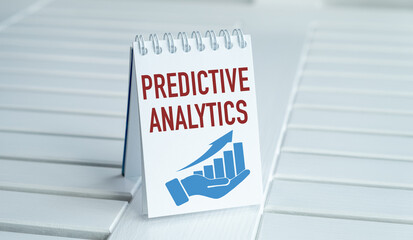 A white spiral bound notebook with the word Predictive Analytics written on it
