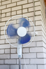 The standing fan circulates air indoors, offering comfort and a refreshing breeze