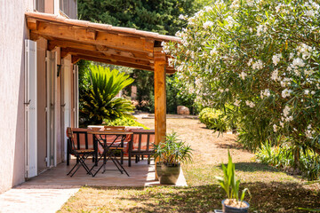 Obraz premium Charming Garden Patio with Wooden Pergola and Outdoor Dining Table