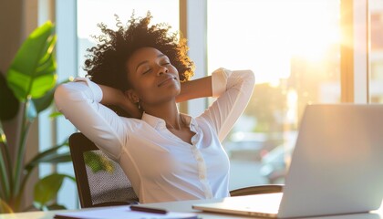 Confident Black woman sitting in a relaxed pose at her desk in a bright and stylish workspace