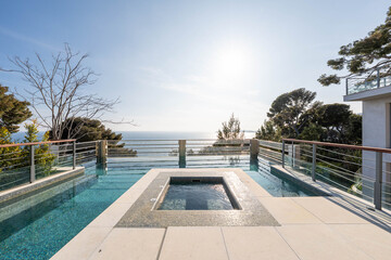 Infinity pool with jacuzzi and panoramic sea view on the French Riviera – luxury villa terrace under morning sun, modern architecture and Mediterranean elegance