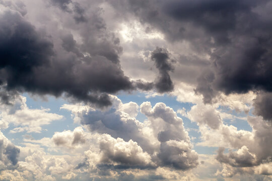 Dark clouds above and light clouds below intersect in the sky, dark and white swirling clouds divide the sky in half close-up, weather change as a sign of bad weather - Powered by Adobe