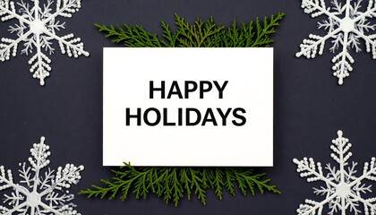 White card with "Happy Holidays" text, surrounded by snowflakes and greenery on a dark gray background