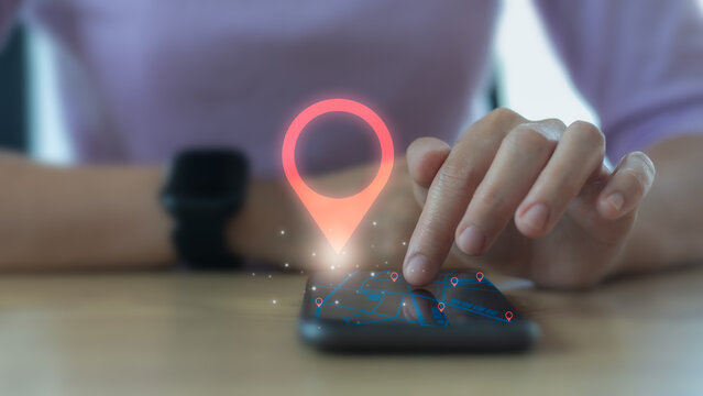 Hand tapping on smartphone with GPS map and location pin hologram, symbolizing navigation, geolocation, and mobile location services.