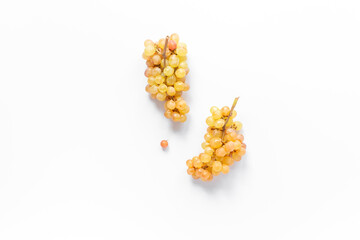 Many bunches of ripe yellow grapes on white background, top view
