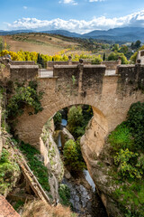 The Puente Viejo, Old Bridge, beside the ancient city walls of Ronda, southern Spain, with a scenic view of the surrounding Serran&iacute;a de Ronda mountain range of Andalucia.
