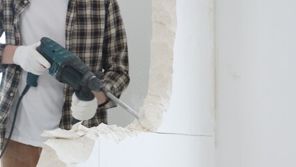 Close up of unrecognizable male construction worker wearing beige checkered shirt and protective...