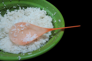 rice in a bowl Plastic spoon with leftover Black  rice, placed on a plain white background