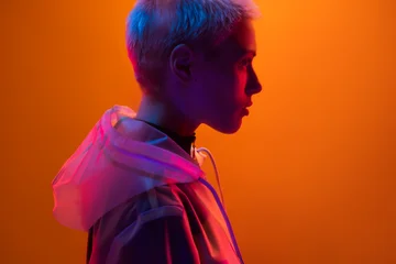 Profile of a woman illuminated by futuristic neon lights, creating a vivid and captivating contrast. © kegfire