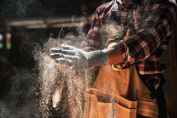 Close Up on Skilled African American Carpenter Dusts Gloves In Woodshop Highlighting Clean Craft,...