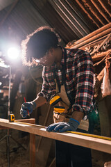 Factory Worker Measuring Timber Plank in Wood Sawmill, African American Man Preparing Wood for...