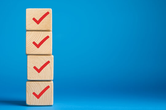 Checklist concept. Correct sign tick check mark on wooden block with copy space for the checklist on blue background. Business survey questionnaire, Exam test process - Powered by Adobe