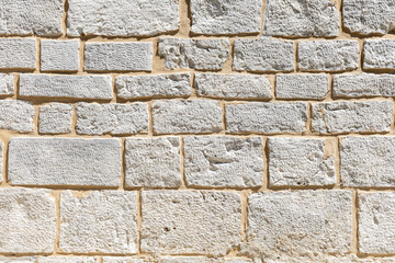 Textured stone wall with irregular patterns and varying shades of gray, showcasing natural materials and architectural design elements for backgrounds