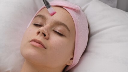 Woman Receiving Relaxing Facial Treatment at a Spa Center