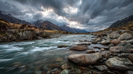 Wide scenic shot of a river winding through a valley under a dramatic cloudy sky