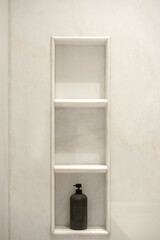 White marble bathroom walls and built-in shelves. Luxurious and minimalist bathroom design suitable...