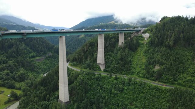 Real-time drone footage showing vehicles traveling and pausing on the iconic Brenner Bridge in Tyrol, a vital Alpine crossing on the Austria&ndash;Italy route.