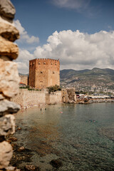 Explore the beauty of a Alanya harbor and marina nestled by the mountains in this serene coastal view
