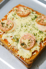 Homemade pizza made from white bread with sausage and cheese toppings