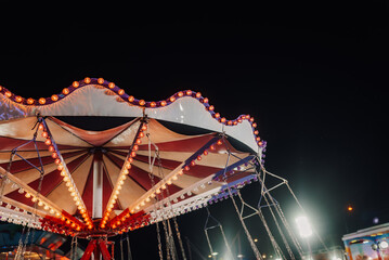 Swing ride canopy illuminated at night in amusement park