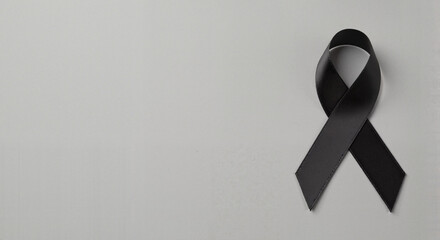 Black awareness ribbon on gray, with space for text