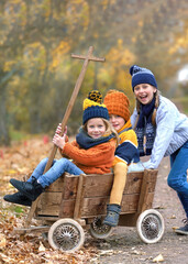 Golden Fall Moments: Happy Kids in a Rustic Wagon