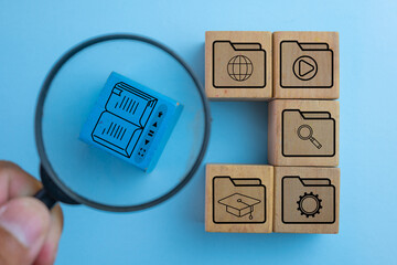 Online education and e-learning concept. Magnifying glass focuses on a digital course icon with...