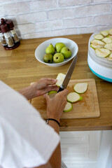 Slicing fresh pears in a cozy kitchen to prepare for a delightful drying process