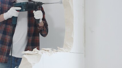 Close up of unknown male construction worker wearing red checkered shirt jeans and protective...