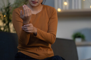 Health Awareness: Young woman checking her wrist for discomfort