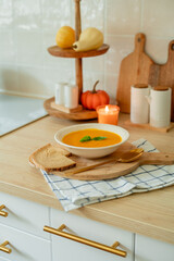 Plate of hot pumpkin soup and a slice of dark bread on the table. Warm autumn food. Immunity.